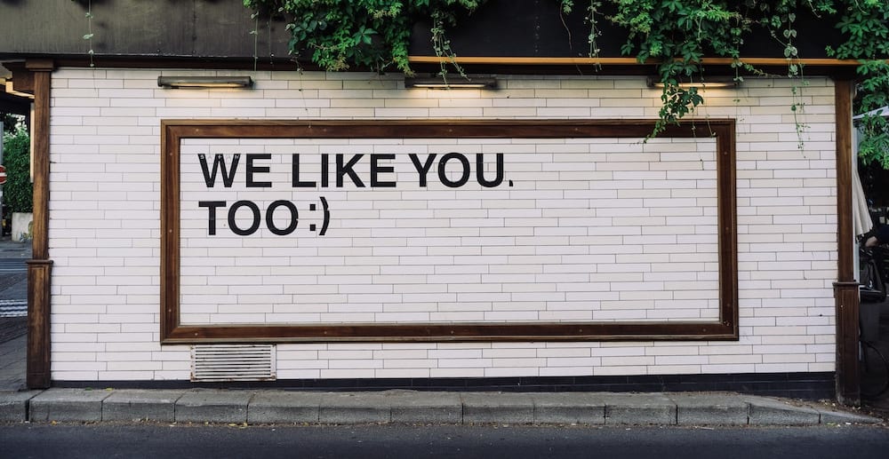 Wandbild mit dem Schriftzug „WE LIKE YOU. TOO :)“